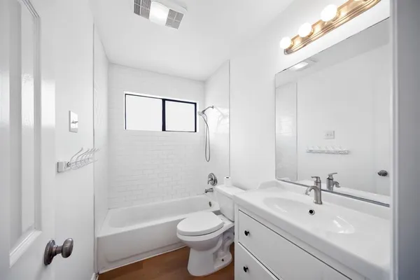 a bathroom with a bathtub a sink a toilet and a mirror
