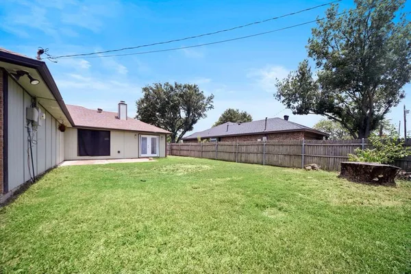 a view of a house with a big yard plants and large tree