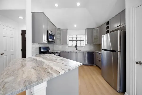 a kitchen with stainless steel appliances granite countertop a refrigerator a sink a stove a microwave and island