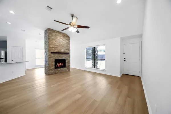a view of empty room with wooden floor and fireplace