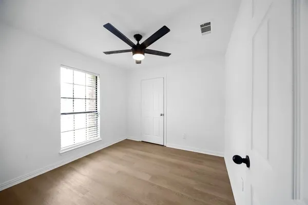 a view of a big room with wooden floor closet and windows