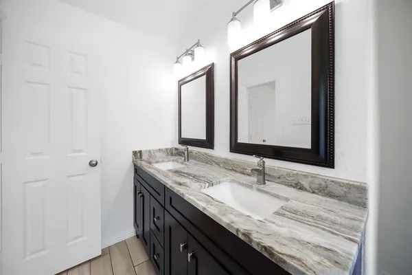 a bathroom with a granite countertop sink and a mirror