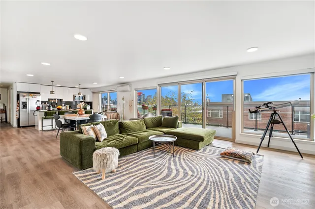 a view of a dining room and livingroom with furniture wooden floor a chandelier