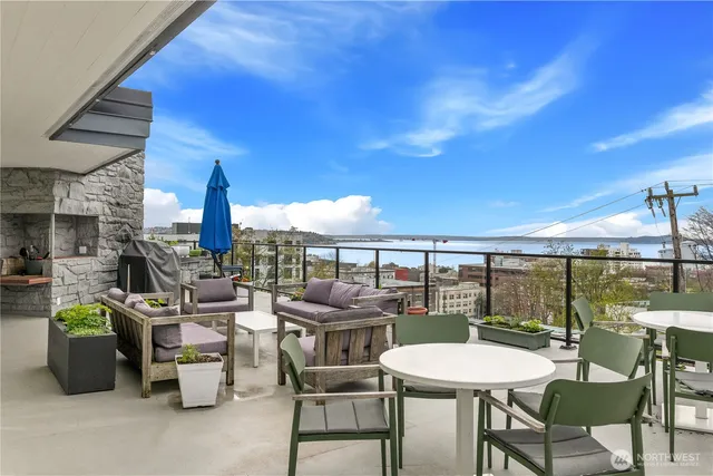 a view of roof deck with couches and sky view
