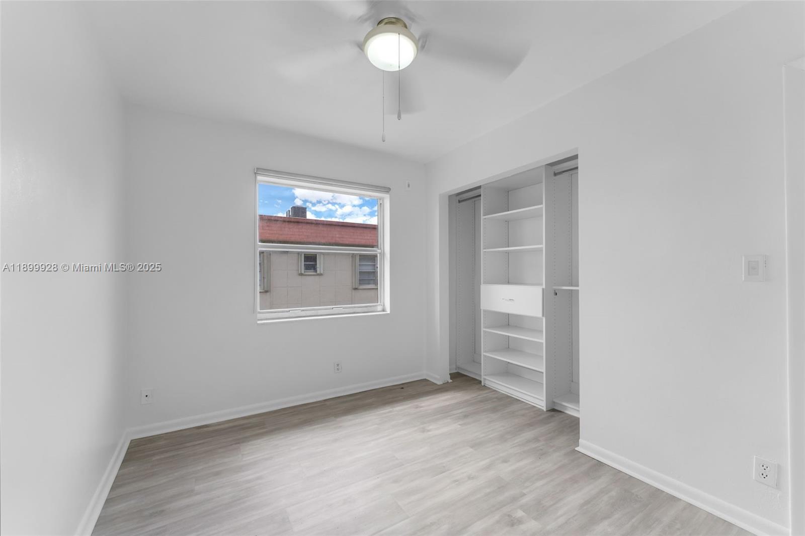 12820 Southwest 43rd Drive, Unit 233B Miami, FL 33175 - Photo 13 of 22 a view of empty room with wooden floor and fan