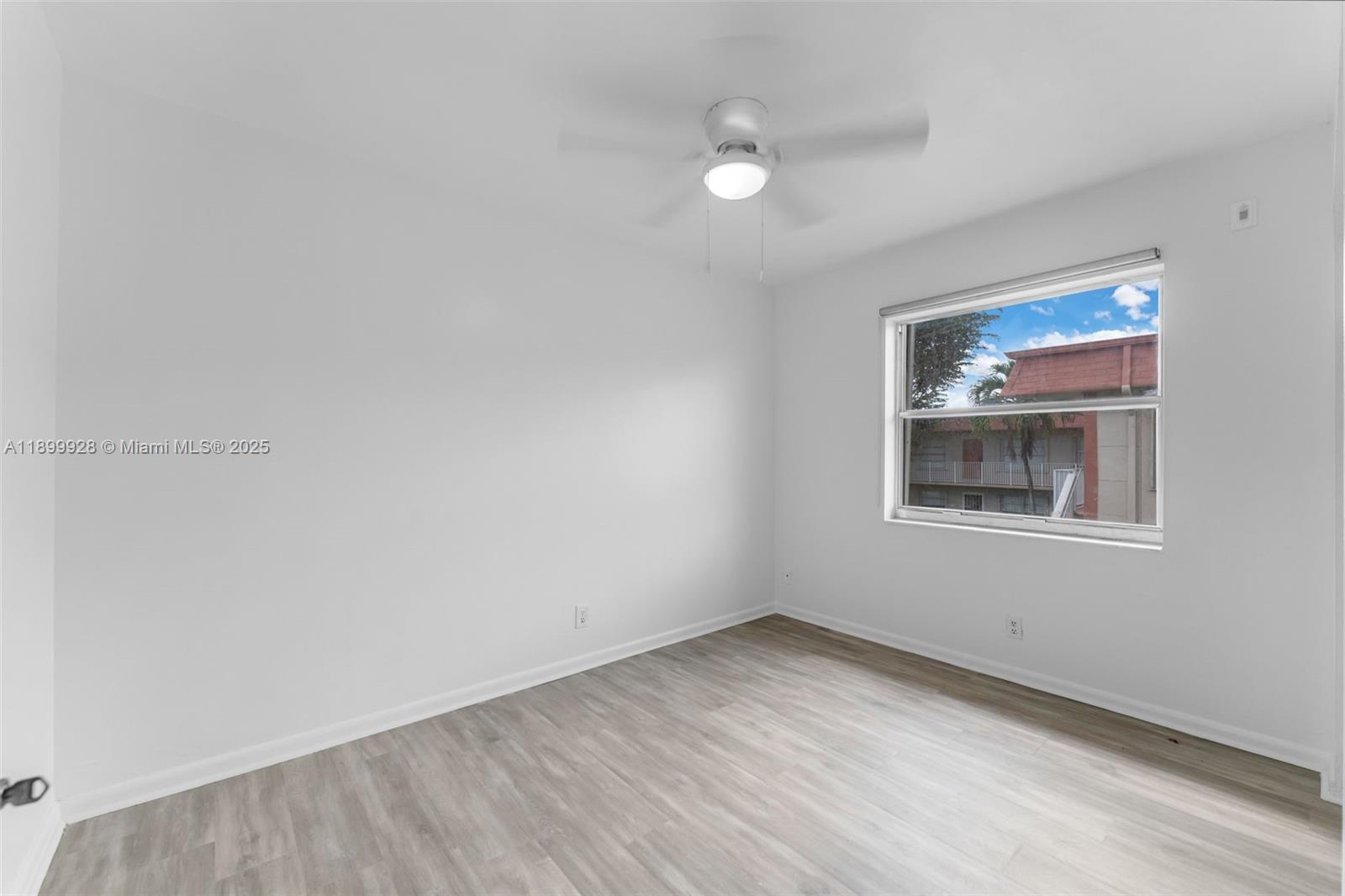 12820 Southwest 43rd Drive, Unit 233B Miami, FL 33175 - Photo 14 of 22 a view of an empty room with wooden floor and a window
