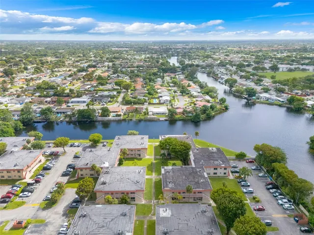 an aerial view of residential houses with outdoor space and ocean view