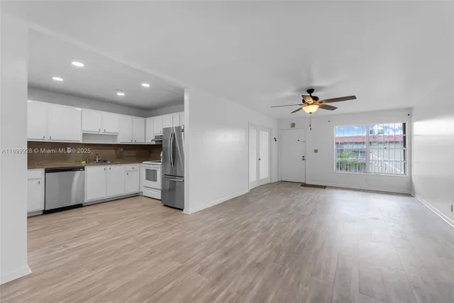 a kitchen with stainless steel appliances a refrigerator and wooden floor