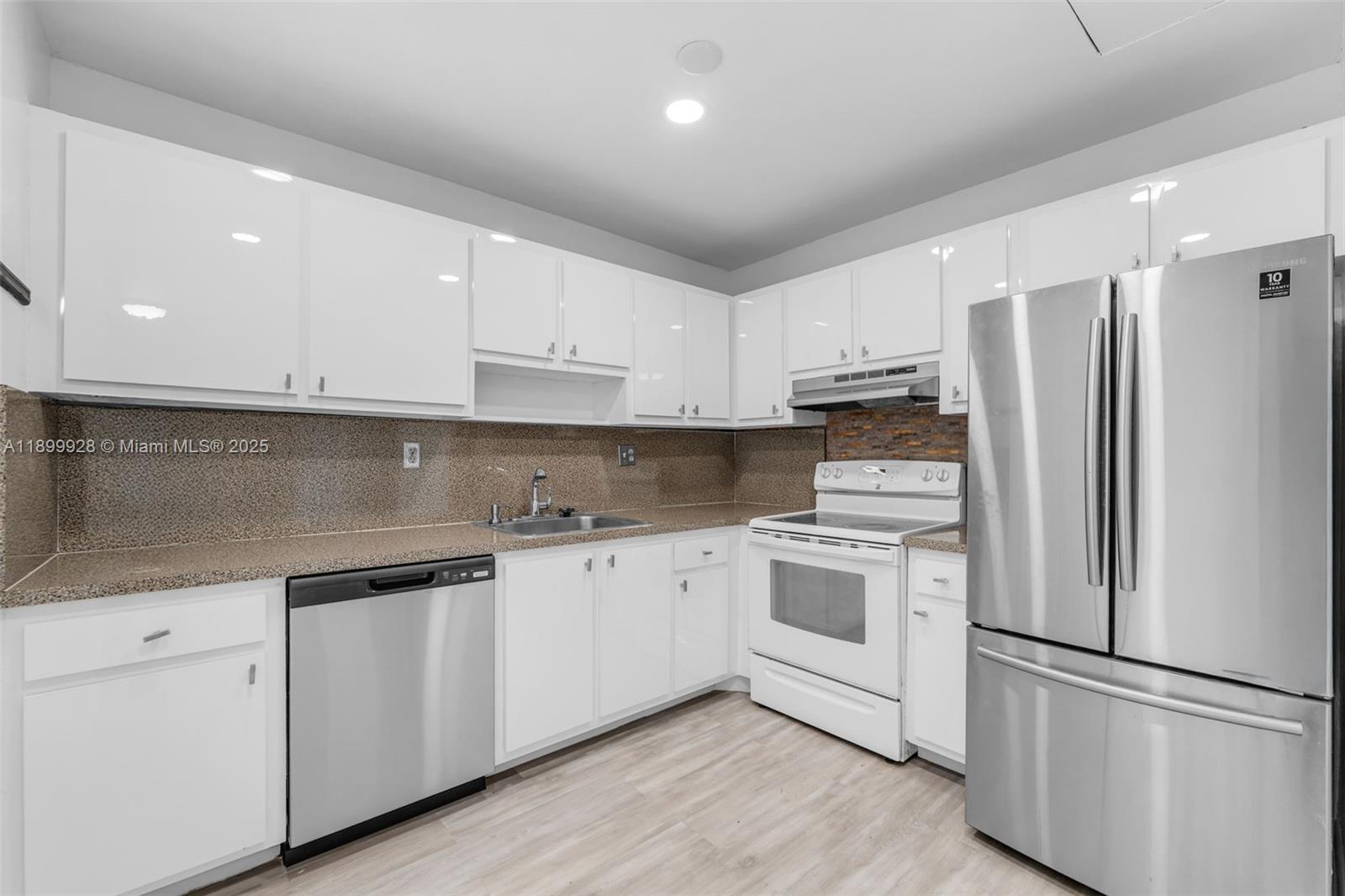 12820 Southwest 43rd Drive, Unit 233B Miami, FL 33175 - Photo 6 of 22 a kitchen with stainless steel appliances white cabinets and a refrigerator
