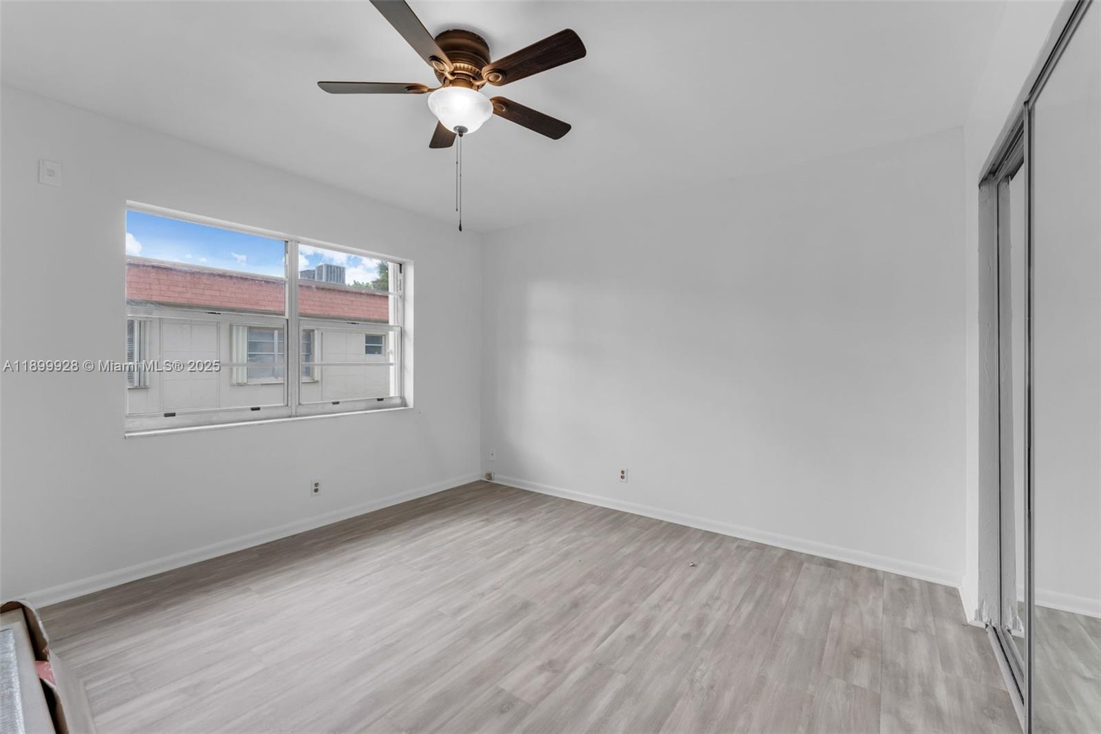 12820 Southwest 43rd Drive, Unit 233B Miami, FL 33175 - Photo 9 of 22 wooden floor in an empty room with a window
