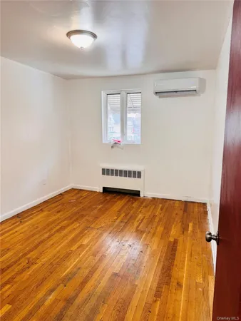 an empty room with wooden floor and natural light