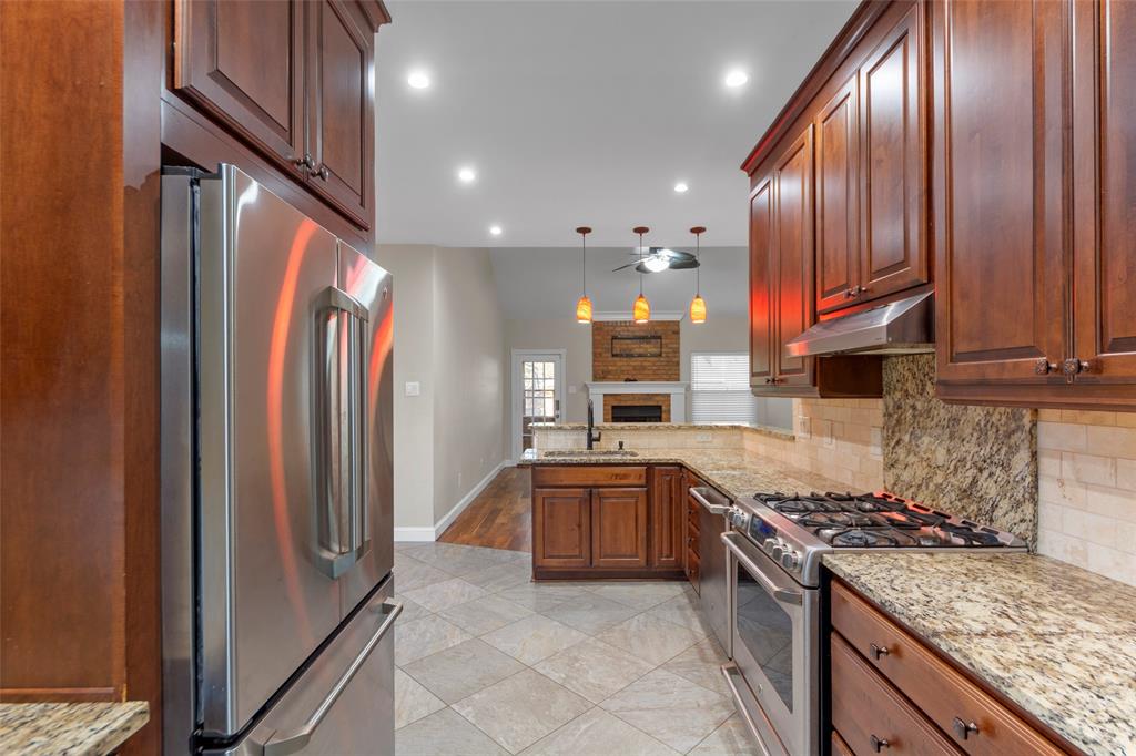 6840 Rochelle Drive Plano, TX 75023 - Photo 4 of 40 a kitchen with stainless steel appliances granite countertop a refrigerator a sink and wooden cabinets