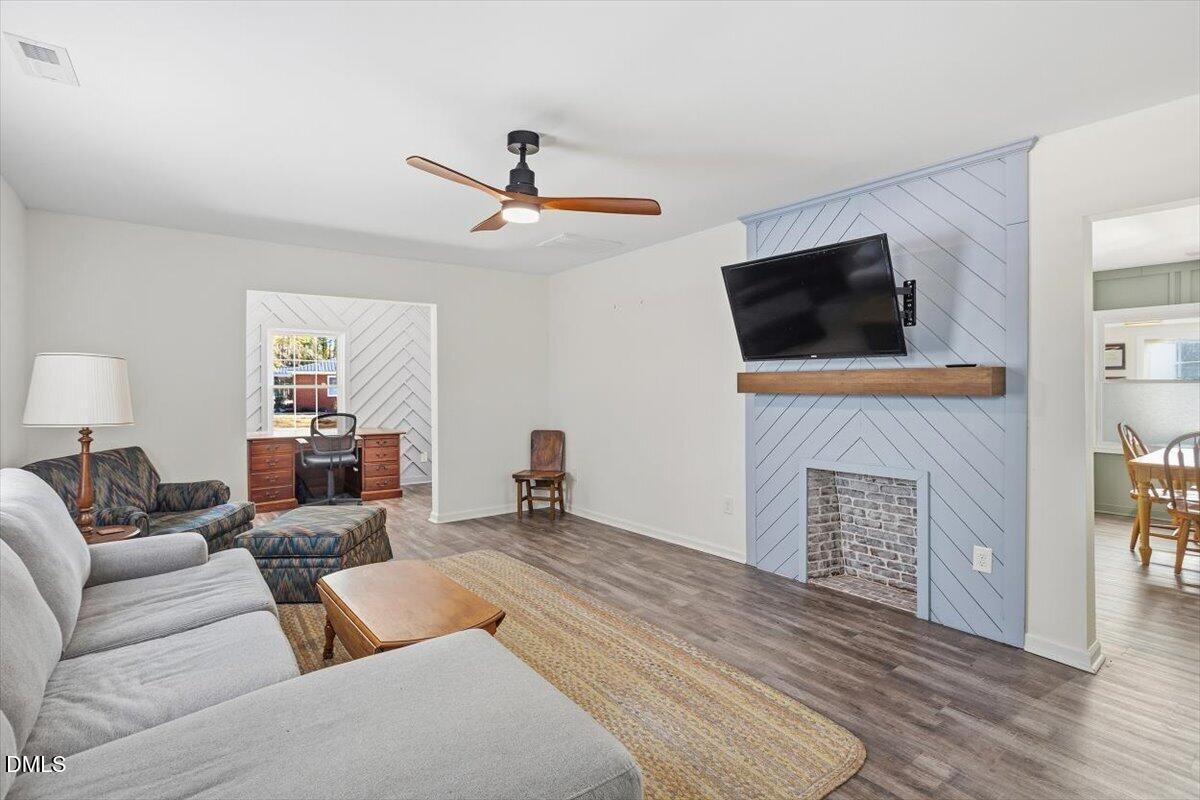 962 Laurel Mill-Centerville Road Louisburg, NC 27549 - Photo 3 of 31 a living room with furniture a fireplace and a flat screen tv