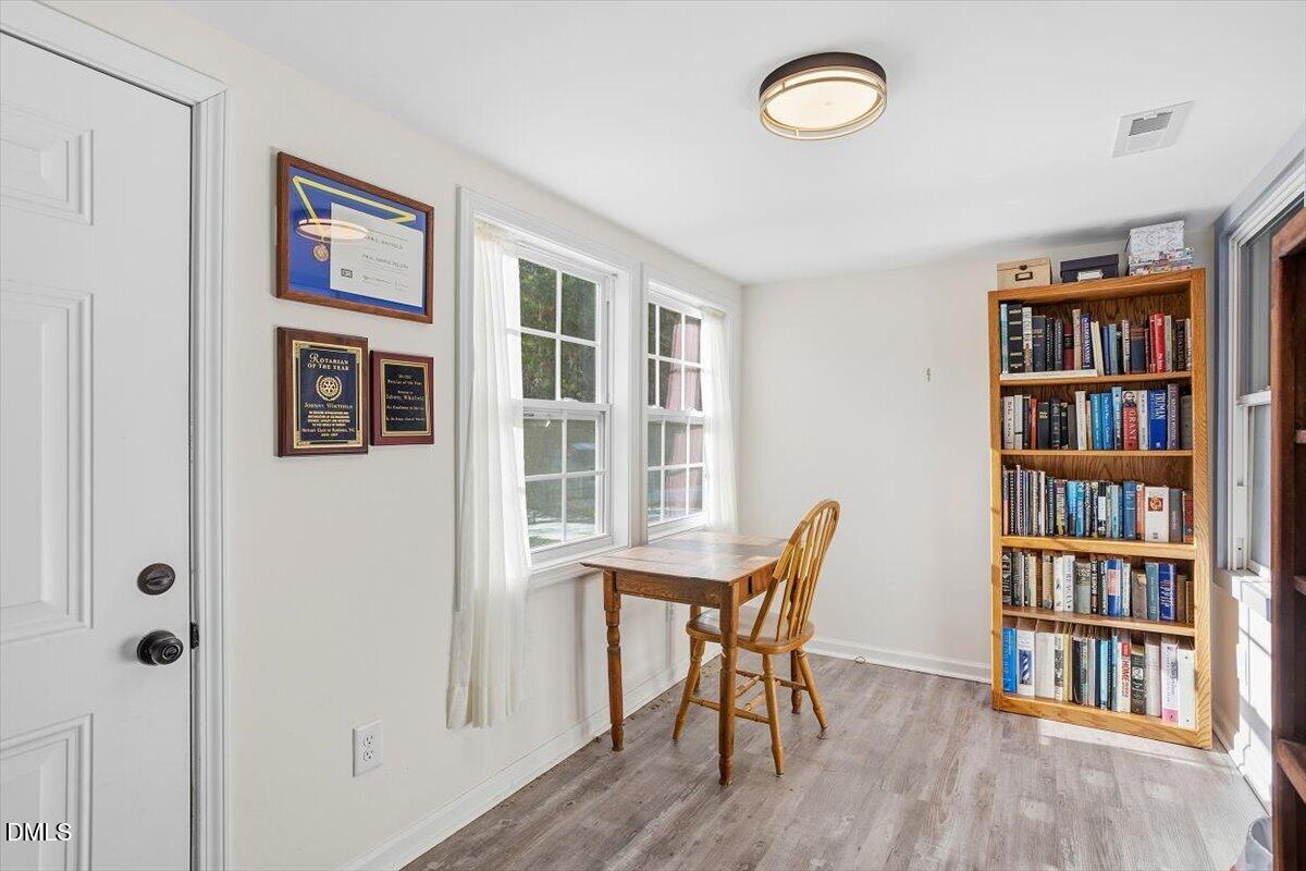962 Laurel Mill-Centerville Road Louisburg, NC 27549 - Photo 9 of 31 a view of a workspace with furniture and a book shelf