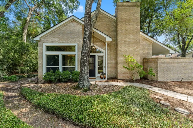 a front view of a house with a yard and potted plants