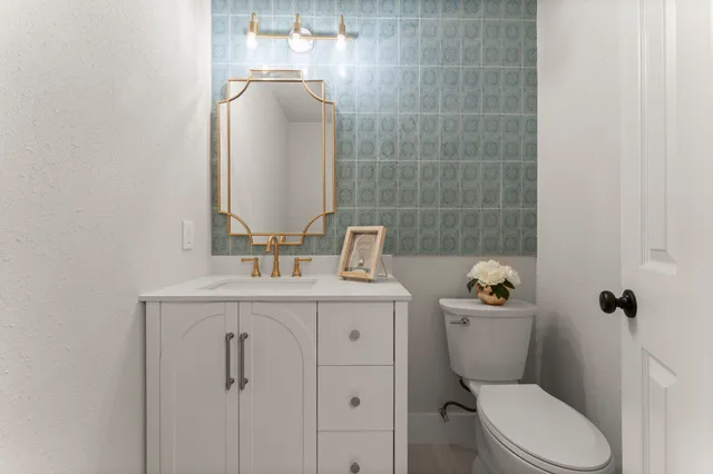 a bathroom with a toilet a sink and mirror
