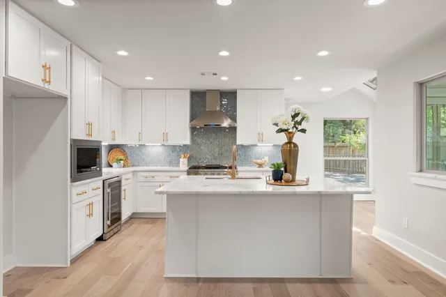 a kitchen with kitchen island sink stove and refrigerator