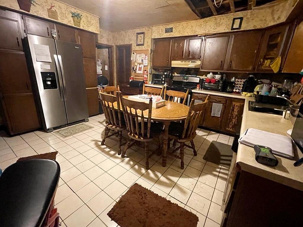 412 Shingiss Street McKees Rocks, PA 15136 - Photo 2 of 14 a kitchen with stainless steel appliances kitchen island granite countertop a table chairs and a refrigerator