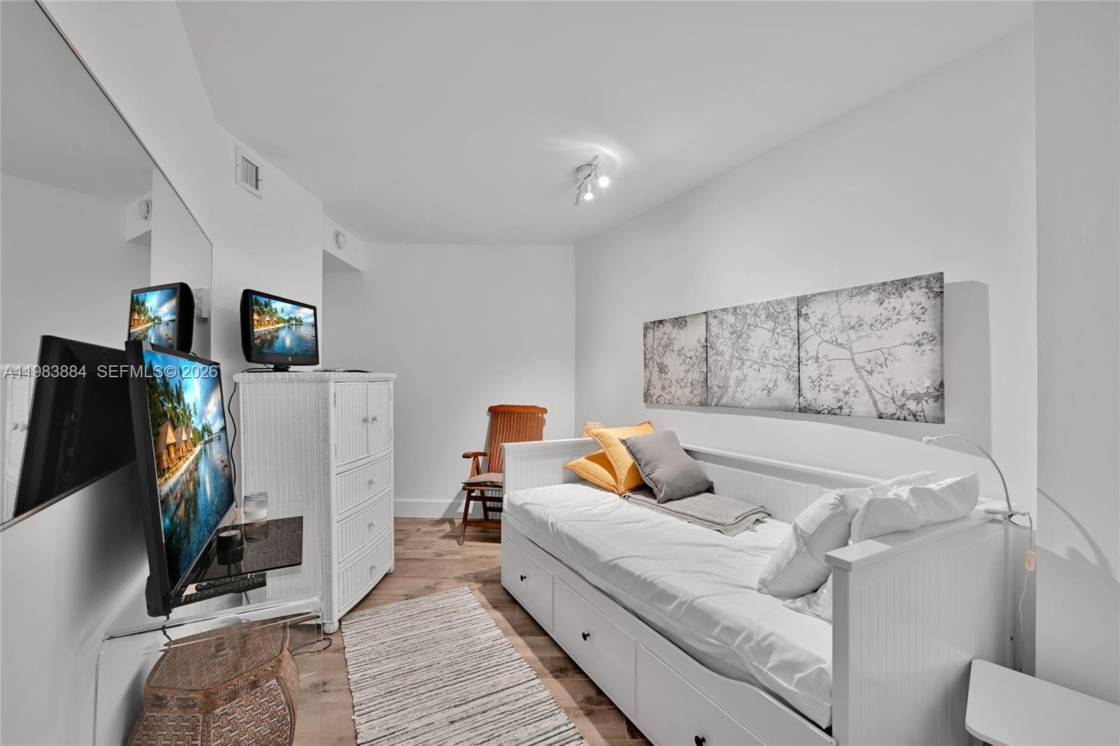 1111 Crandon Boulevard, Unit C504 Key Biscayne, FL 33149 - Photo 11 of 18 a bed room with a bed and a flat screen tv