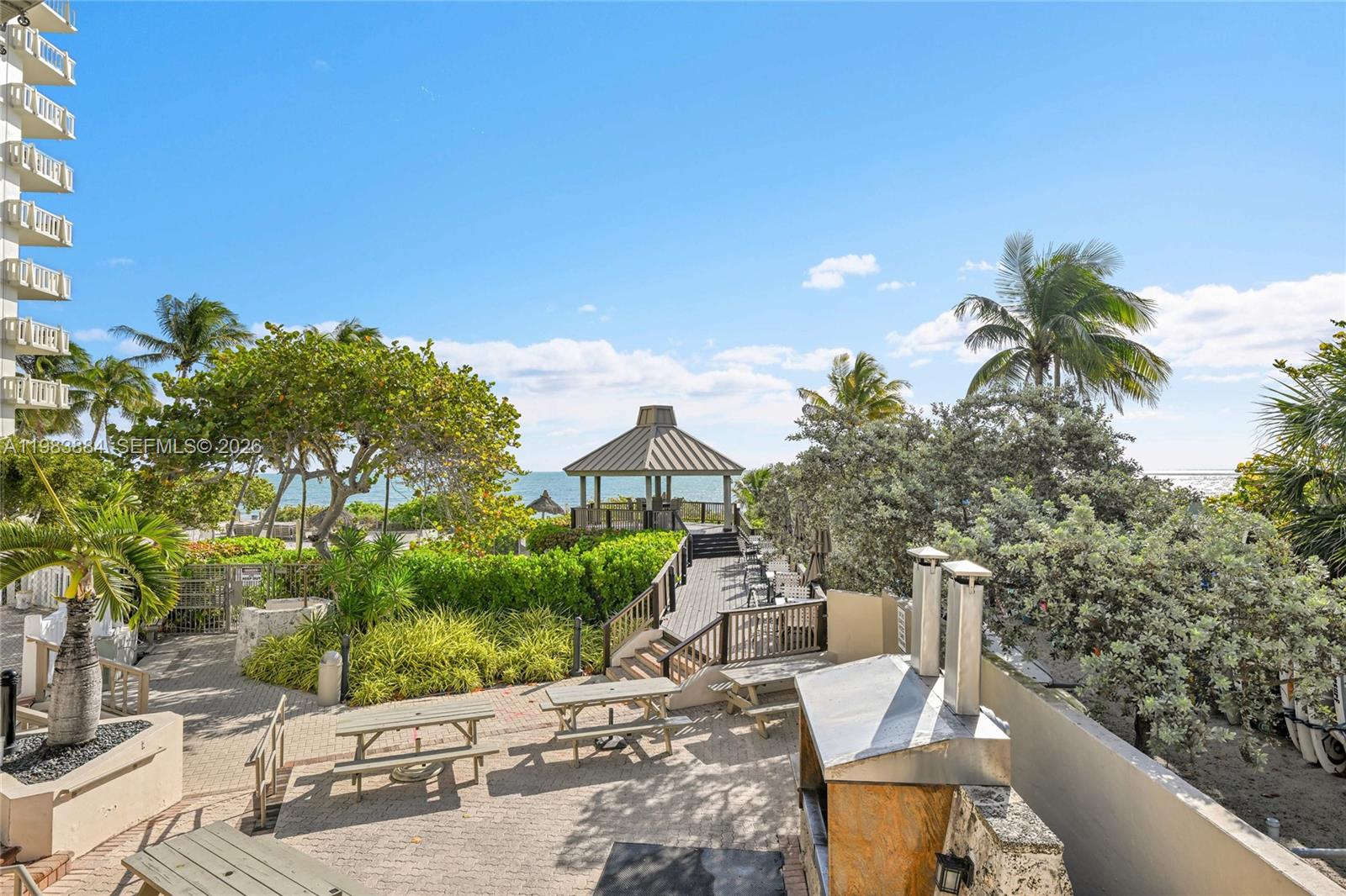 1111 Crandon Boulevard, Unit C504 Key Biscayne, FL 33149 - Photo 15 of 18 a backyard of a house with table and chairs under an umbrella