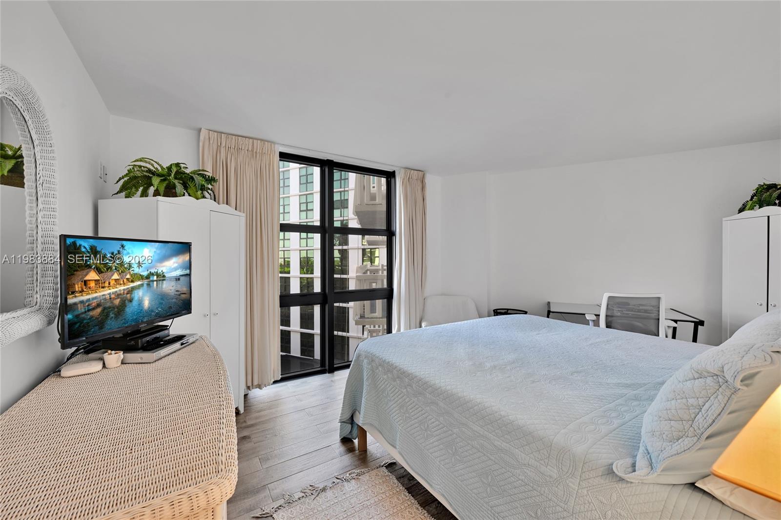 1111 Crandon Boulevard, Unit C504 Key Biscayne, FL 33149 - Photo 8 of 18 a bedroom with a bed and a flat screen tv