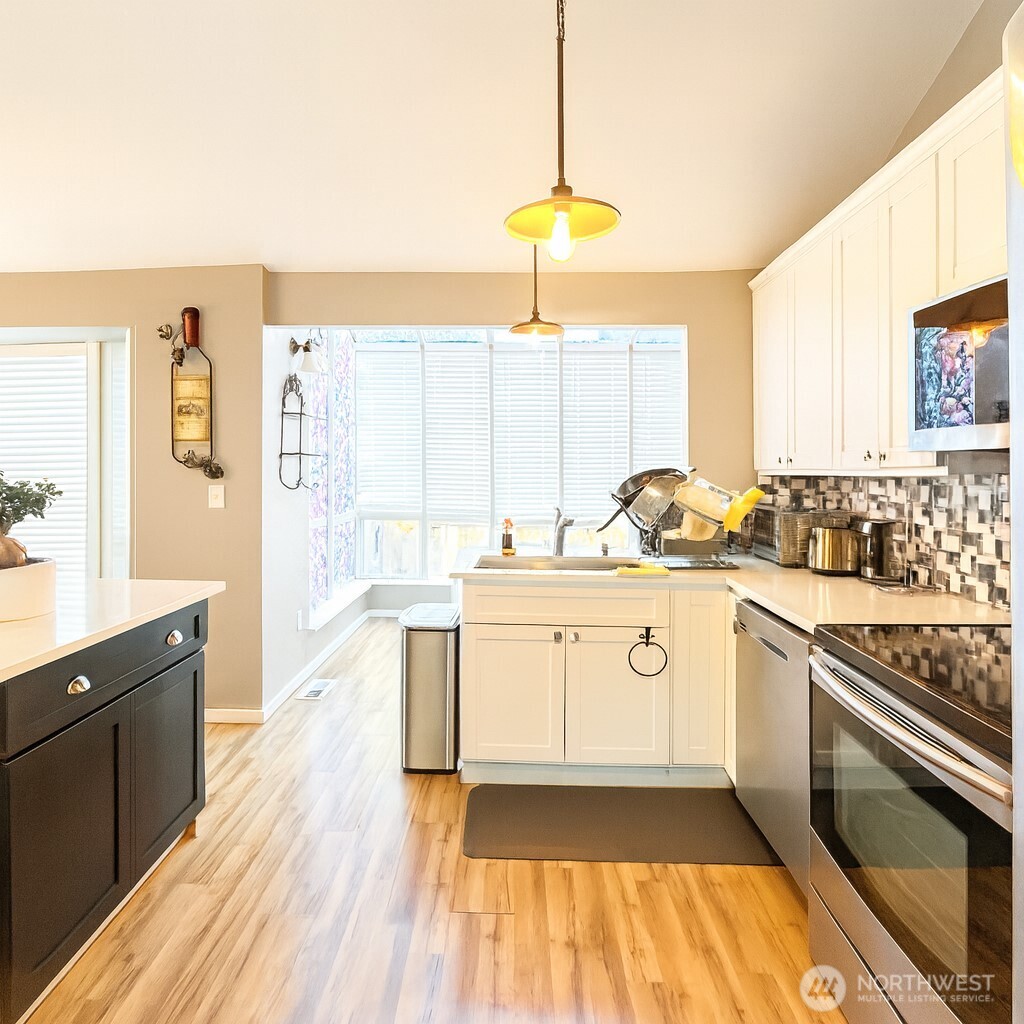 1723 Southwest 324th Street Federal Way, WA 98023 - Photo 5 of 21 a kitchen with a sink stove and white cabinets