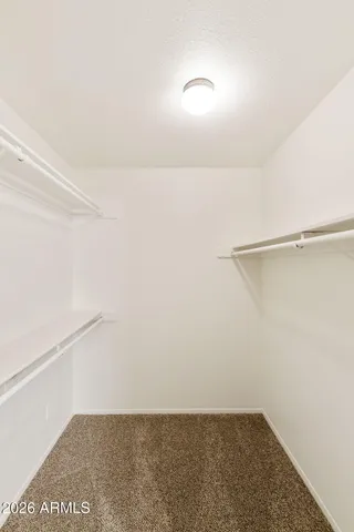 a view of an empty room with cabinet and a window
