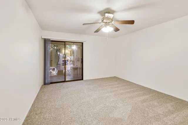 an empty room with closet and a chandelier fan