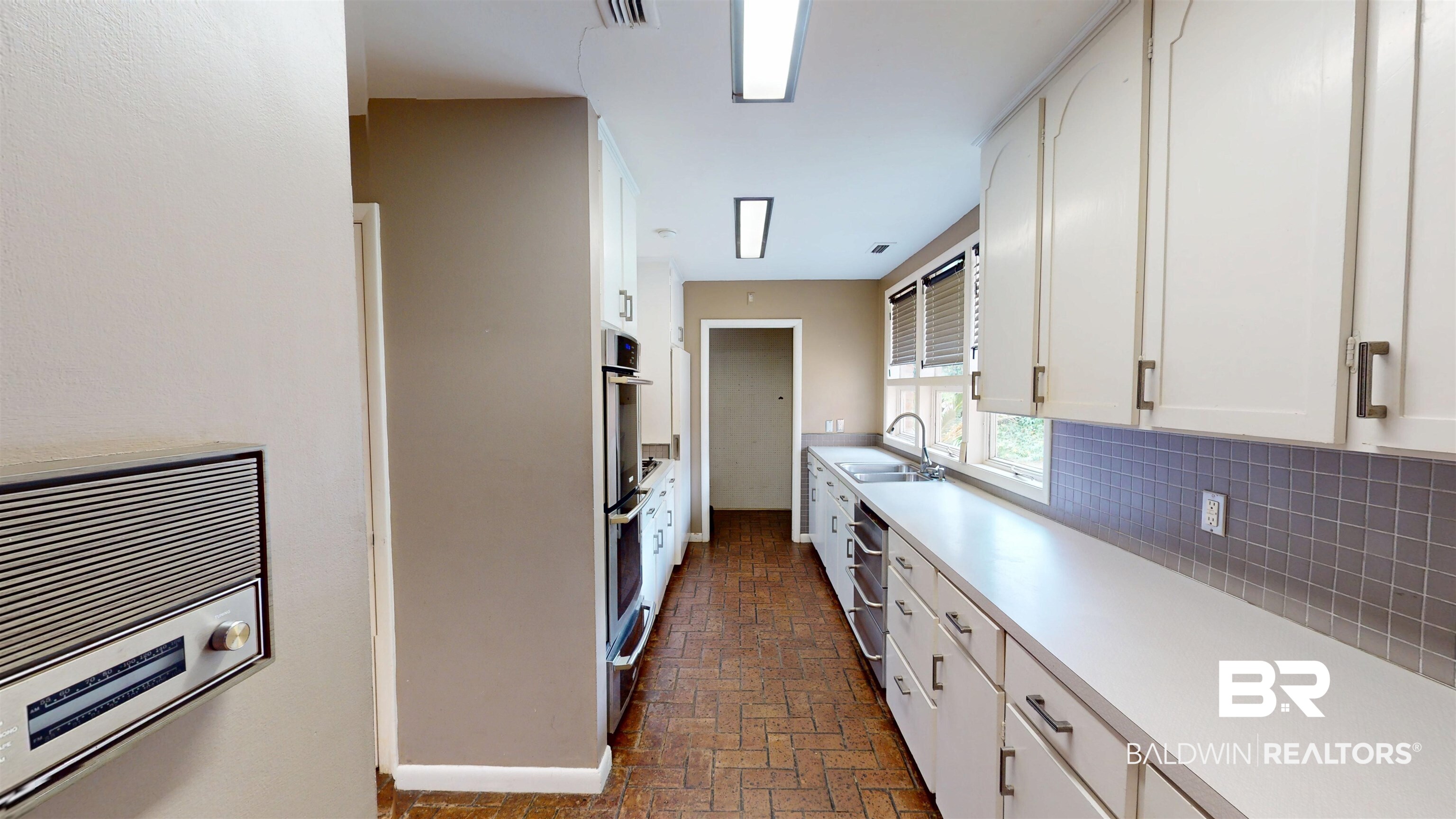 15 Spring Bank Road Mobile, AL 36608 - Photo 23 of 58 Kitchen with brick floors, light countertops, white cabinetry, tasteful backsplash, and a warming drawer