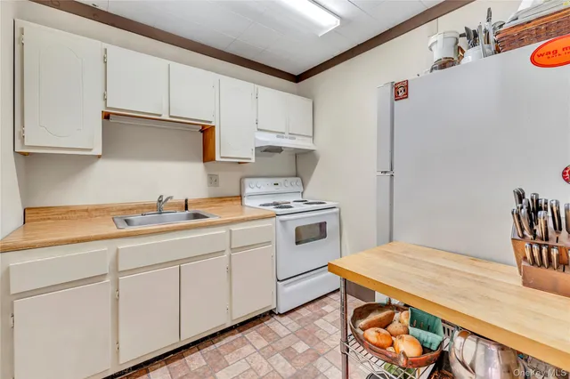 a kitchen with stainless steel appliances granite countertop a sink a stove a refrigerator and cabinets