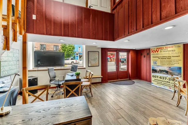 a living room with furniture a flat screen tv and floor to ceiling window