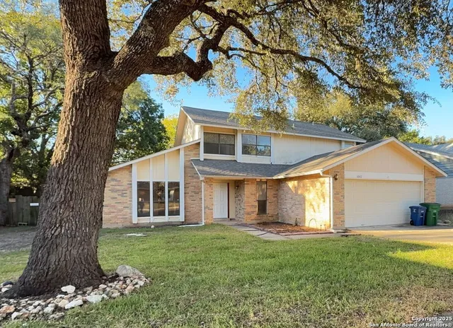 a front view of a house with a garden and yard
