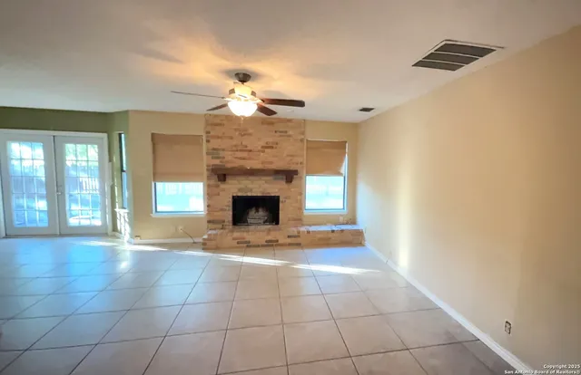 a view of an empty room with a fireplace and a window