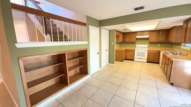 a kitchen with stainless steel appliances kitchen island granite countertop a refrigerator and a stove top oven