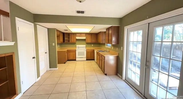 a large kitchen with stainless steel appliances granite countertop a refrigerator and a sink
