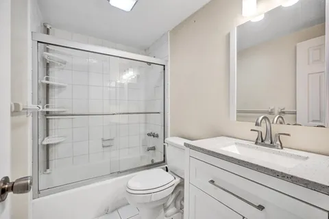 a bathroom with a granite countertop sink toilet and shower