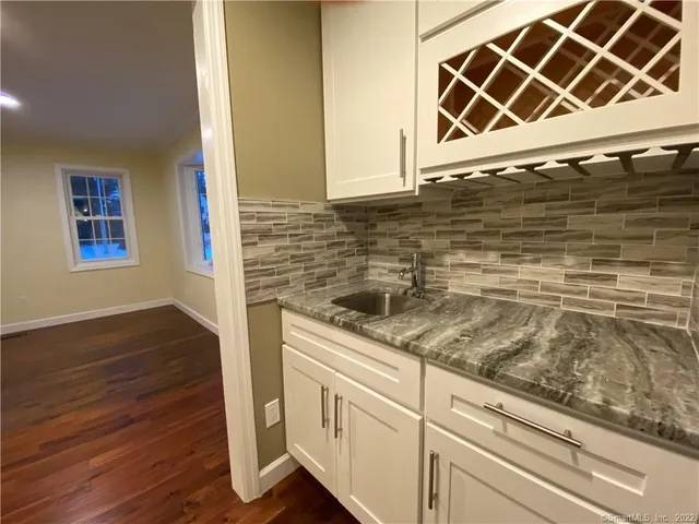 a kitchen with granite countertop a sink and a wooden floor