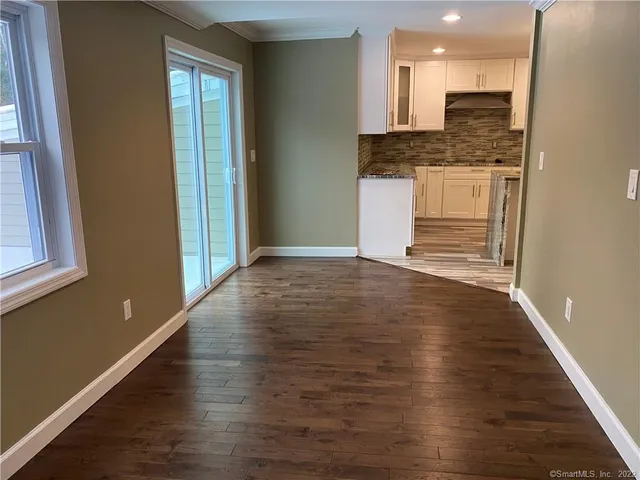 a view of kitchen with stainless steel appliances granite countertop cabinets and wooden floor