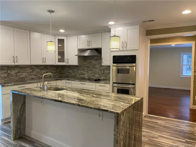 a kitchen with stainless steel appliances granite countertop a sink and a stove