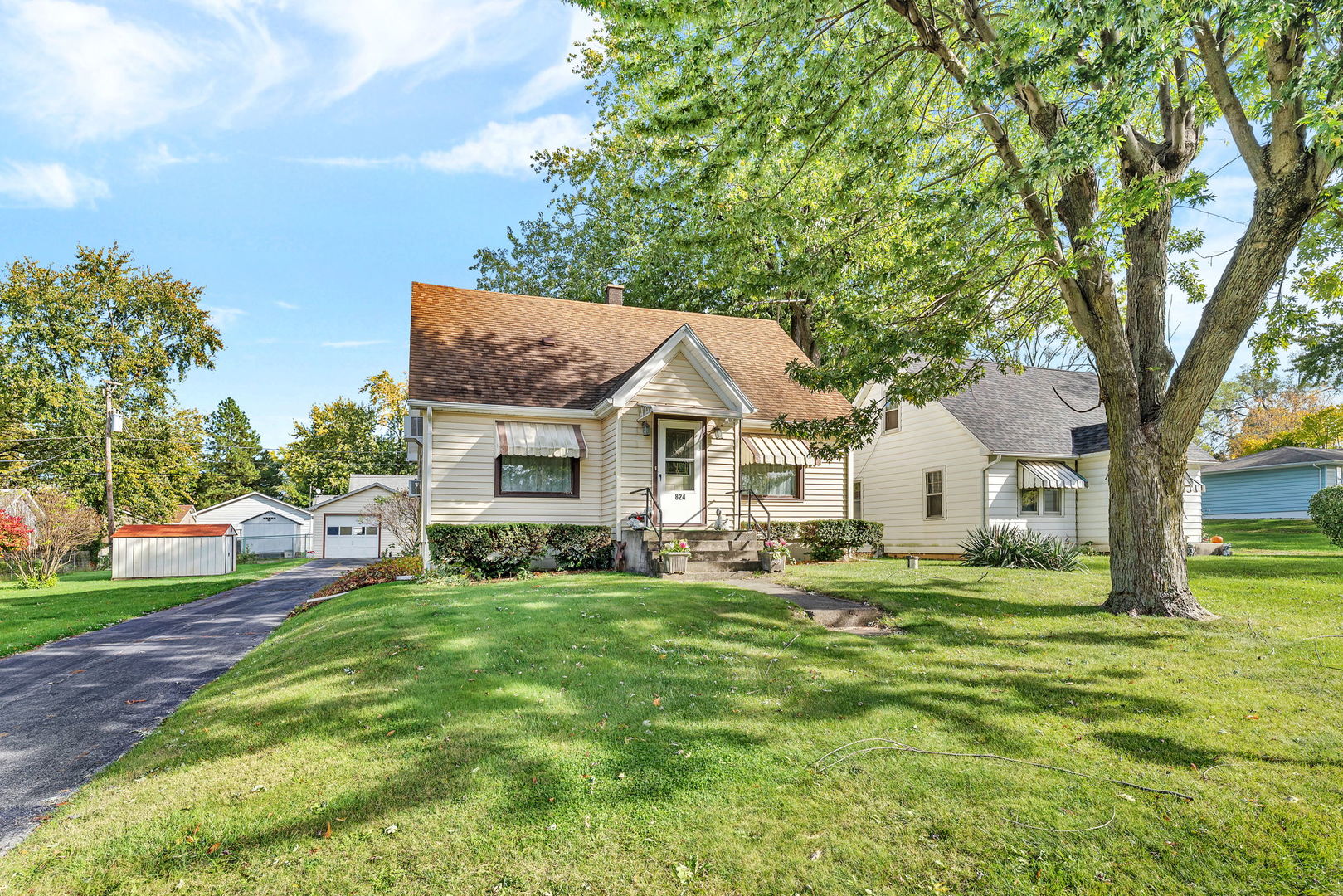 a view of a house with a big yard plants and large trees