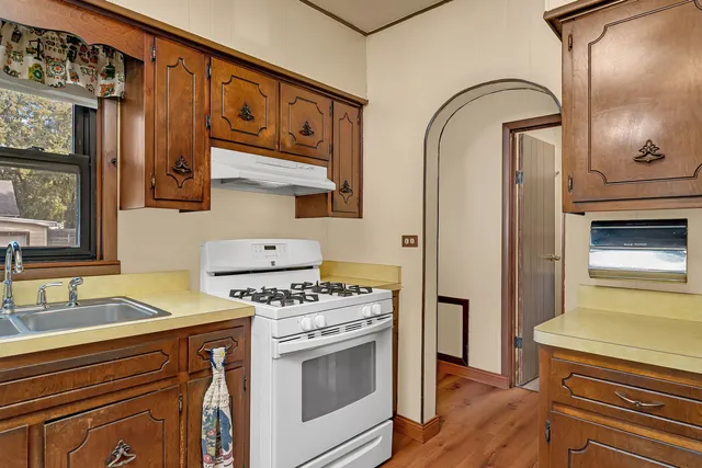 a kitchen with stainless steel appliances granite countertop a stove a sink and cabinets