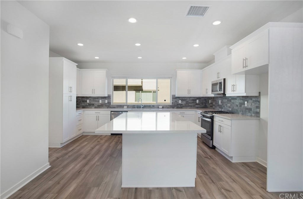 404 Coyote Pass Blanchard, ID 83804 - Photo 3 of 22 a large kitchen with kitchen island a sink a stove a center island and cabinets