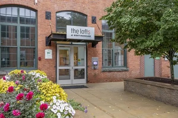 a front view of a multi story residential apartment building with a yard
