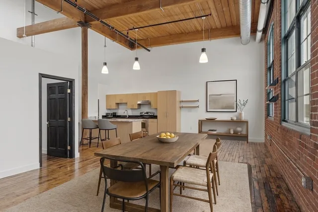 a living room with a table chairs and a refrigerator