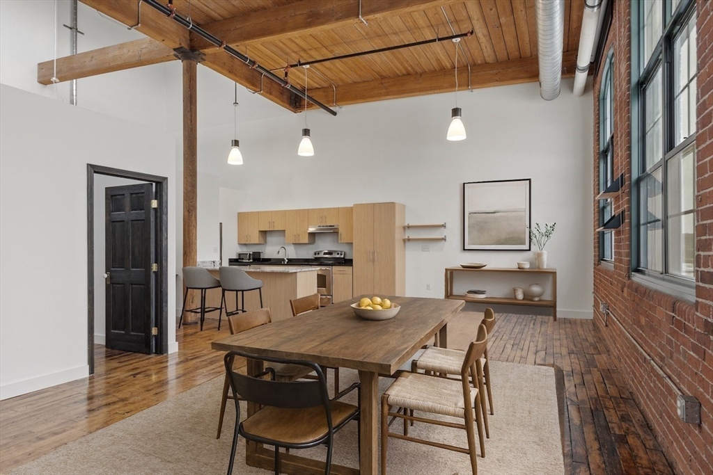 1 Westinghouse Plaza, Unit C334 Boston, MA 02136 - Photo 3 of 13 a living room with a table chairs and a refrigerator