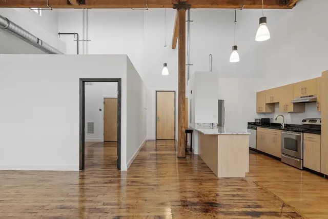 a large kitchen with cabinets and wooden floor