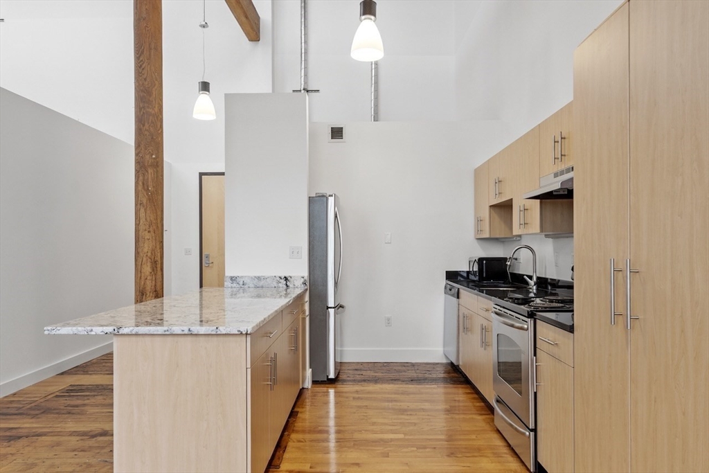 1 Westinghouse Plaza, Unit C334 Boston, MA 02136 - Photo 8 of 13 a kitchen with stainless steel appliances granite countertop a stove and a refrigerator