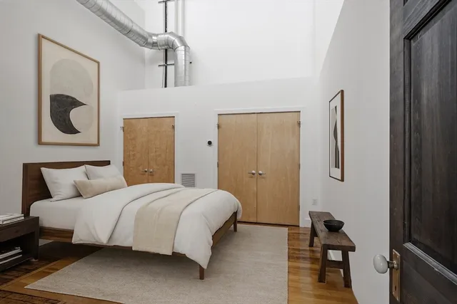 a bedroom with a bed and wooden floor