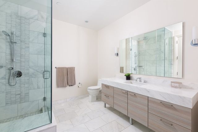 a spacious bathroom with a shower sink and mirror