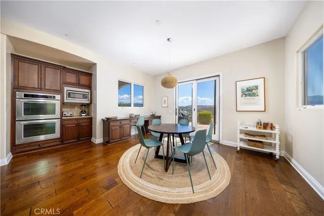 a large kitchen with stainless steel appliances kitchen island granite countertop a large counter top and view of living room